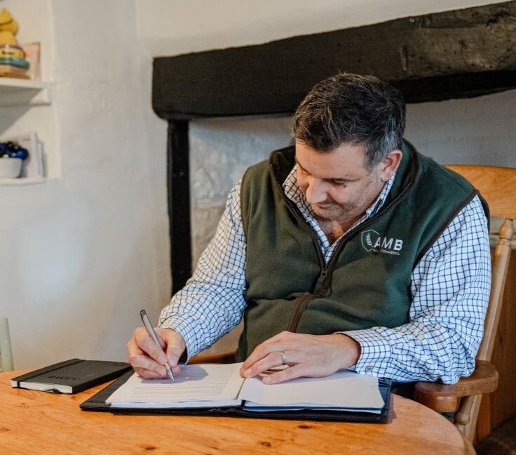Insurance advisor reviewing home and contents paperwork at a kitchen table, representing personalised household cover advice
